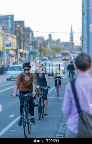 Les cyclistes parcourir la piste cyclable pendant la trajet du matin sur Fitzroy Street, à Melbourne, Victoria, Australie Banque D'Images