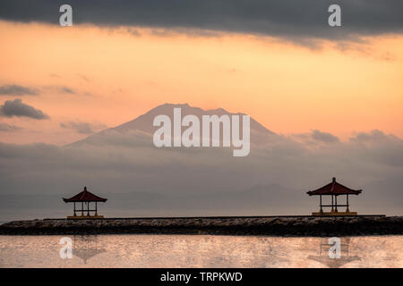 Mont Agung (volcan) avec deux pavilion sur ponton de la plage de Sanur, Bali Banque D'Images