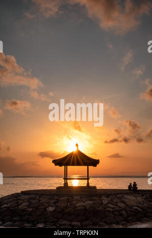 Plus de soleil sur pavillon jetée à côte dans matin. La plage de Sanur, Bali Banque D'Images