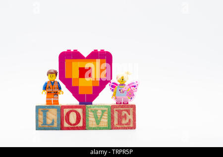 Emmet lego avec butterfly girl et offrant pièce de forme de coeur. Figurines Lego sont fabriqués par les Lego. Banque D'Images