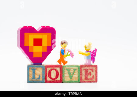 Emmet lego pour fille papillon fleur donnant morceau et offrant une forme de coeur. Figurines Lego sont fabriqués par les Lego. Banque D'Images