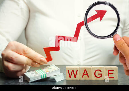 La main féminine détient la flèche vers le haut au-dessus des mots. Augmentation de salaire, les taux de salaire. La promotion, l'avancement de carrière. L'amélioration du niveau de vie. Augmenter les profits Banque D'Images