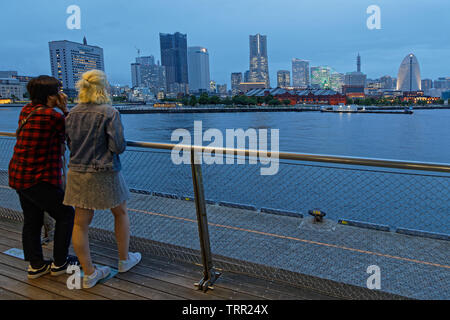 YOKOHAMA, Japon, 20 mai 2019 : Couple admire la vue sur l'horizon port de Yokohama à l'Heure Bleue. Port de Yokohama sert 38000 navires par an. Banque D'Images