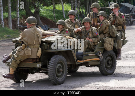 Sept participants déguisés en soldats de l'Armée U.S 82nd Airborne Division "tous américains" sur une Jeep Banque D'Images