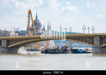 Grue et d'exploitation des bateaux de travail sur le site d'un accident où deux bateaux se sont abordés sous le pont Margaret avec le bâtiment du parlement hongrois. Banque D'Images