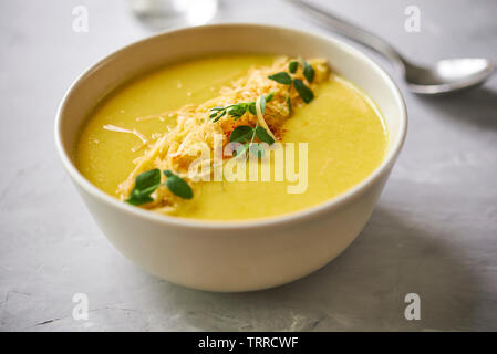 Soupe de fromage à la crème jaune avec des germes de pois dans un bol Banque D'Images