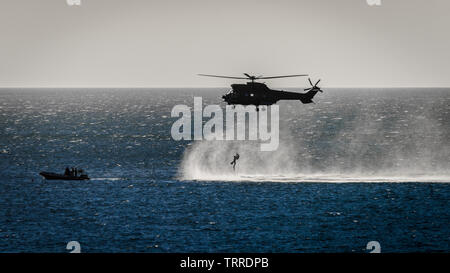 L'Armée de l'air sud-africaine hélicoptère Oryx descend un homme de la False Bay eaux au cours d'un exercice d'entraînement près de la base navale de Simons Town Banque D'Images