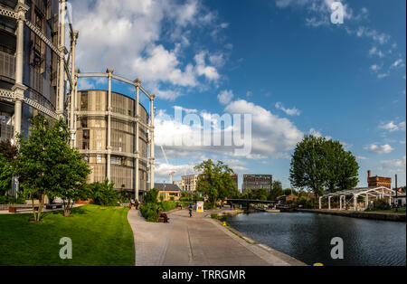 Londres, Angleterre, Royaume-Uni - juin 3, 2019 : les piétons et cyclistes le long du voyage Regents Canal de halage à côté des gazomètres bâtiments dans le King's Cros Banque D'Images