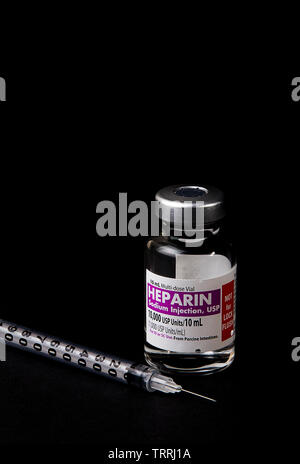 Une bouteille de l'anticoagulant Héparine sodique avec une seringue sur un fond noir Banque D'Images