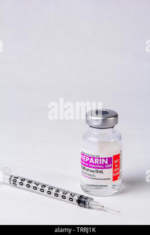 Une bouteille de l'anticoagulant Héparine sodique avec une seringue sur un fond blanc Banque D'Images