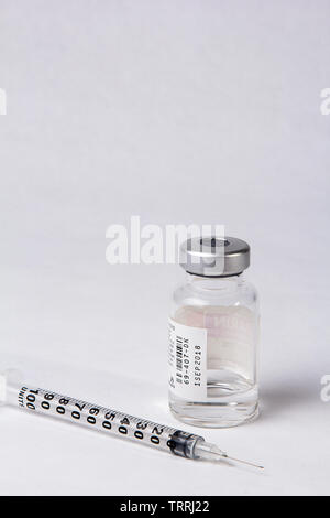 Une bouteille de l'anticoagulant Héparine sodique avec une seringue sur un fond blanc Banque D'Images