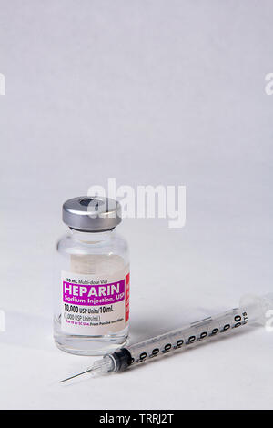 Une bouteille de l'anticoagulant Héparine sodique avec une seringue sur un fond blanc Banque D'Images