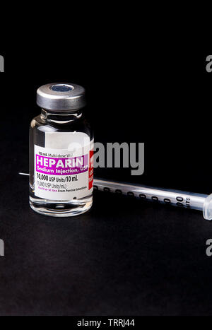 Une bouteille de l'anticoagulant Héparine sodique avec une seringue sur un fond noir Banque D'Images