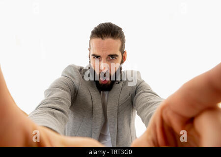 Drôle jeune homme barbu blogger hipster style décontracté moderne à tenir l'appareil photo ou téléphone intelligent auto portrait prise de vue ou d'enregistrement vidéo pour ses followe Banque D'Images