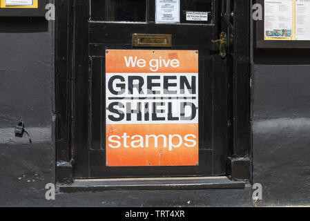 Vintage panneau disant "nous donner à Green Shield stamps" joint à la porte du café à Gloucester, Gloucestershire, Royaume-Uni Banque D'Images