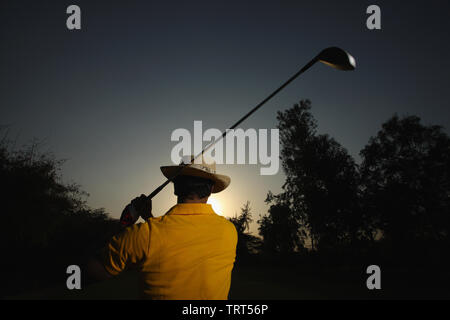 Rear view of a man swinging a golf club Stock Photo