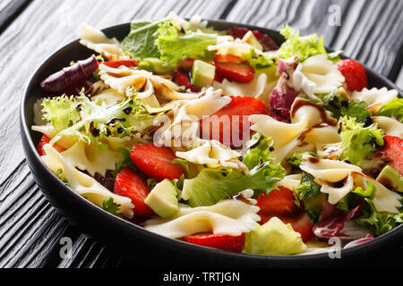 Salade de pâtes farfalle rafraîchissante avec de l'avocat, les fraises, la laitue et la sauce balsamique close-up sur une plaque sur la table horizontale. Banque D'Images