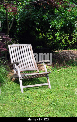 Une vieille chaise pliante en teck dans une cour arrière Banque D'Images