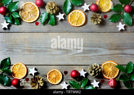 Composition de Noël avec des tranches d'orange, cônes, saint, étoiles, boules rouges et petits coeurs sur fond de bois Banque D'Images