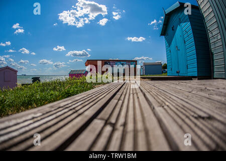 Jolies cabines de plage de couleur sur l'île de Mersea dans l'Essex. Banque D'Images