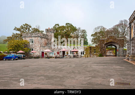 Recherche à travers le parvis de l'hôtel propose un café à l'intérieur ou à l'extérieur de la pierre ancienne château adjacent à un parc vert montrant la porte au-delà Banque D'Images