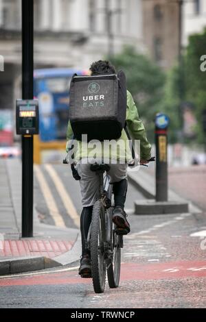 Un Uber mange à emporter rider livraison déclenche avec son sac à dos rempli d'ordres isolés à Manchester, au Royaume-Uni. Banque D'Images