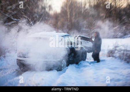 Processus de mise hors voiture suv coincé dans la neige, les hommes de creuser et en poussant la voiture hors de la neige, le concept de voiture avec problèmes d'hiver Banque D'Images