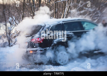 Processus de mise hors voiture suv coincé dans la neige, les hommes de creuser et en poussant la voiture hors de la neige, le concept de voiture avec problèmes d'hiver Banque D'Images