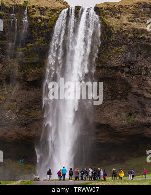 SELJALANDSFOSS, ISLANDE - Touristes à cascade sur la côte sud, sur Seljalands River. Banque D'Images