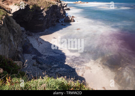 Route des pêcheurs, dans le sud-ouest du Portugal, avec ses formations rocheuses et l'eau cristalline, avec des tons de rouge que les algues donne à l'eau. Banque D'Images