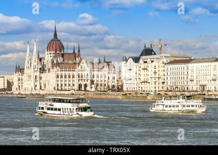 BUDAPEST, HONGRIE - Mars 2018 : Deux petits bateaux de croisière touristique visite touristique passant sur le bord du Danube, dans le centre-ville de Budapest. Banque D'Images