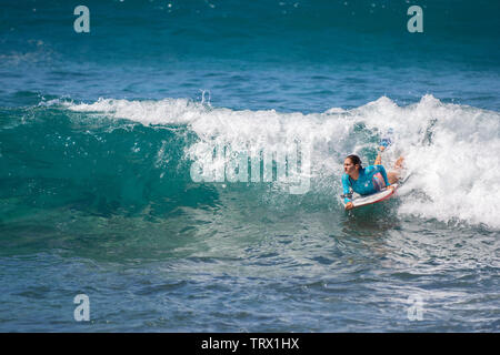 Un jeune homme body-board, Hilo, Hawaii. Banque D'Images