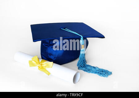 Graduation cap bleu ou mortier avec blue tassel et diplôme avec ruban jaune, isolé sur fond blanc. Banque D'Images