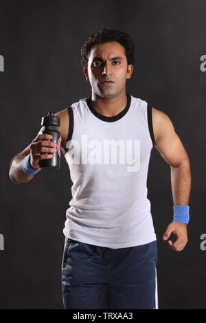 Portrait d'un athlète masculin tenant une boisson pour sportifs Banque D'Images
