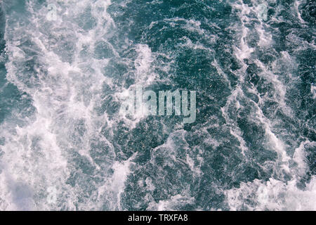 Faites par la turbulence de l'eau de mer de mousse d'un yacht à grande vitesse sur la surface de la mer. Les vagues de la mer bleue avec beaucoup d'écume de mer. Surface de mer avec les vagues. Banque D'Images