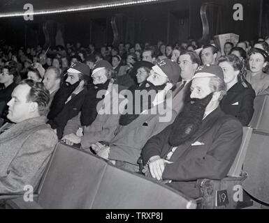 Audience dans les années 1940. Un groupe de quatre hommes sont assis dans un cinéma, toutes les fausses barbes. Suède 1948. Kristoffersson ref AP100-3 Banque D'Images