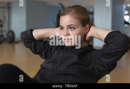 Young caucasian woman girl faisant des craquements d'entraînement à la salle de sport sur son abs Banque D'Images