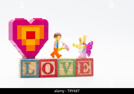 Emmet lego pour fille papillon fleur donnant morceau et offrant une forme de coeur. Figurines LEGO sont fabriquées par le Lego Banque D'Images