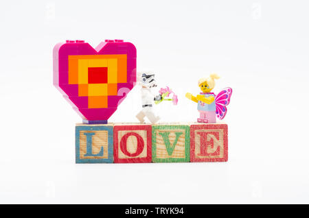 Storm Trooper lego fleur donnant de butterfly girl et offrant pièce de forme de coeur. Figurines LEGO sont fabriquées par le Lego Banque D'Images