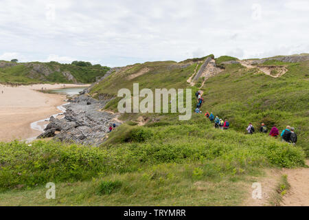 Groupe de marcheurs randonnée le long du chemin de la côte du Pembrokeshire, à vaste Havre de Pembrokeshire, Pays de Galles Banque D'Images