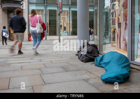 La vie dans les rues, des gens à la rue, à dormir dans la rue, de la pauvreté, chômage, aide sociale, mendiant, tramp, vide de la porte, les lieux publics, pauvres, camping, hébergement, assis, couché, le centre-ville, le centre-ville de Manchester, Royaume-Uni Banque D'Images