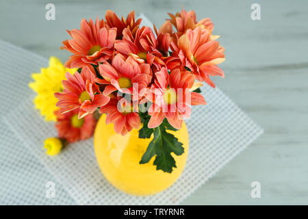 De belles fleurs dans un vase, sur fond de bois Banque D'Images