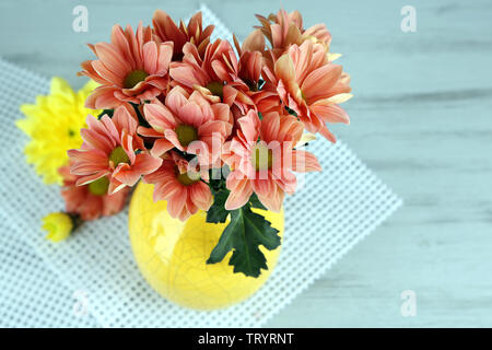 De belles fleurs dans un vase, sur fond de bois Banque D'Images