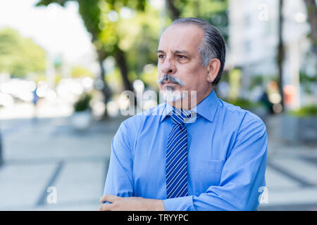 Tiré et triste senior businessman piscine dans la ville Banque D'Images