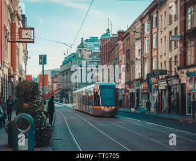 Dublin, Irlande - Septembre 2018. Tramway Luas pour le transport public dans la rue de l'Abbaye avec des bâtiments et des commerces le long du trottoir. Banque D'Images