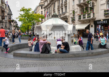 Belgrade, Serbie, 6 juin 2019 : Les gens se reposant autour de fontaine d'eau potable à la rue Knez Mihailova dans la zone piétonne du centre ville Banque D'Images