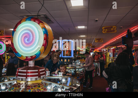 Cromer, UK - 20 Avril 2019 : Les gens de jouer à l'arcade par le bord de mer à Cromer, une ville balnéaire à Norfolk et une destination de vacances famille populaires Banque D'Images