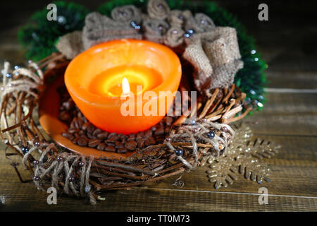 Bougie allumée avec des décorations de Noël sur fond de bois de couleur Banque D'Images