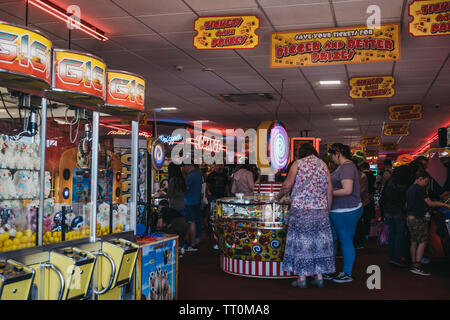Cromer, UK - 20 Avril 2019 : Les gens de jouer à l'arcade par le bord de mer à Cromer, une ville balnéaire à Norfolk et une destination de vacances famille populaires Banque D'Images