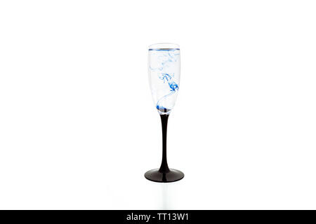 Verre de vin sur fond blanc avec des peintures de couleur bleue à l'intérieur. Fougere pour champagne avec de la fumée et les ensemencer. Banque D'Images